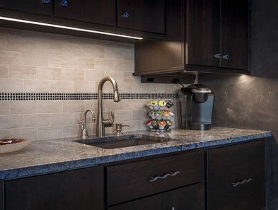 A Task Lighting linear fixture underneath a mounted wall cabinet.